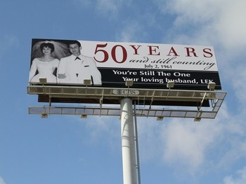 A 50th anniversary billboard is shown with a picture of a couple from the 1960s.